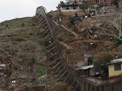 Picture of the US-Mexico Border, taken from Nogales, Arizona. The USA side of the border is on the left of the picture, while the Mexican side is on the right. The camera is pointed towards the east.